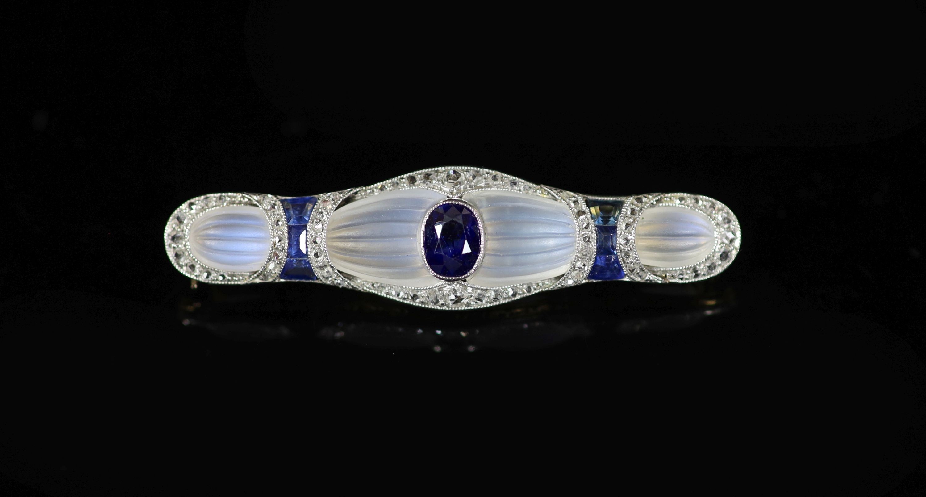 An early 20th century Austrian gold, platinum, millegrain set rose cut diamond and sapphire mounted fluted moonstone bar brooch, by (Konrad?) Koch